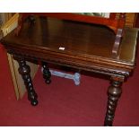 An early 20th century moulded oak round cornered fold-over card table,