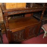 A circa 1900 carved oak ledgeback buffet, having twin floral carved recessed panelled lower doors,
