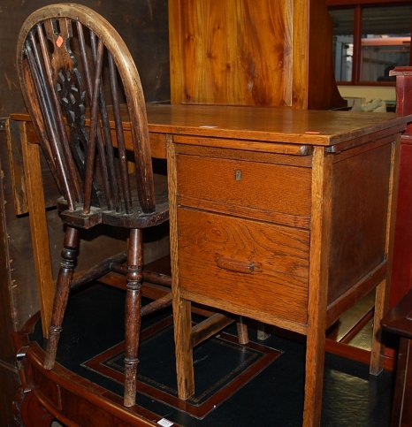 An early 20th century oak single dropflap two drawer desk;