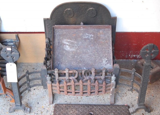 A Gothic Revival cast iron fire basket, having integral fireback and fire dogs,