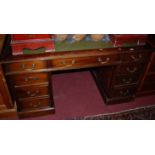 A reproduction mahogany and gilt tooled green leather inset twin pedestal writing desk, w.