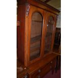 A Victorian mahogany double door glazed bookcase, raised on associated base,