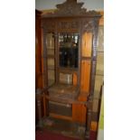 A circa 1900 heavily carved oak mirrorback hallstand, having single central drawer, w.