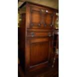 An early 20th century geometric moulded oak side cupboard, having hinged fallfront compartment,