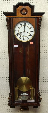 An early 20th century walnut droptrunk wall clock, having glazed trunk door, with twin weights,
