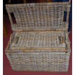 A graduated set of two wicker rectangular carrying baskets and covers