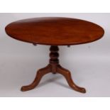A George III mahogany supper table, the circular tilt-top on a turned column and tripod base, dia.