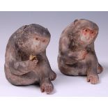 A pair of Japanese late Meiji period (1868-1912) porcelain seated monkeys, heightened in colours,