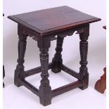 *An early 18th century oak joint stool, having an old replacement top above a shaped frieze,