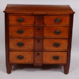 A 19th century Dutch elm commode, fitted with four long graduated drawers, flanked by canted angles,