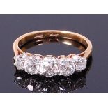 An 18ct gold and platinum diamond five stone ring, the old cut graduated diamonds in a line setting,