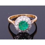 An 18ct gold, emerald and sapphire cluster ring, the centre round cut emerald weighing approx 0.