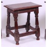 *An 18th century oak joint stool, the top having a moulded edge, on turned and square cut supports,