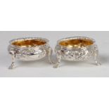 A pair of mid-Victorian silver table salts, each repousee decorated with leaves and flowers,