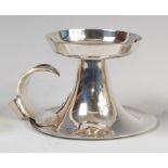 An Edwardian Arts & Crafts silver chamberstick, having detachable sconce over flaring base,