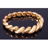 A contemporary 18ct yellow gold bracelet, arranged as graduated finely textured and polished links,