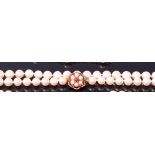 A cultured pearl and knotted single string necklace, having 9ct gold, seed pearl and ruby set clasp,