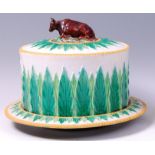 A Victorian George Jones majolica cheese dome on stand, the cover surmounted by a recumbent cow,