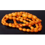 *A beaded butterscotch amber single string long necklace, comprising 97 beads, 73.