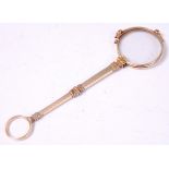 An early 20th century French gold lorgnette, the arm having engine turned decoration,