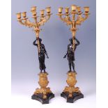 A large pair of late 19th century French bronze and gilt bronze figural five-light candelabra,