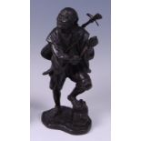 A Japanese Meiji period patinated bronze figure of a standing musician carrying a stringed