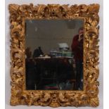 A Rococo period giltwood and gesso picture frame, with later inset mirrorplate,