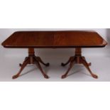 A Regency style mahogany twin pillar dining table, the rectangular top with moulded edge,