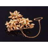 An 18ct gold, emerald and diamond set brooch, arranged as triple flower head clusters,