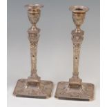A pair of late Victorian Adam style silver candlesticks, each having beaded removable sconces,