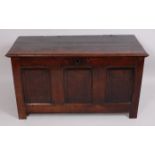 A George III joined oak coffer, the planked top on split-ring hinges above a three panel front,