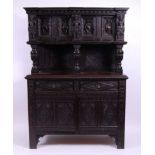 *An antique heavily carved oak hunting cupboard,