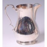 A George VI silver jug, of bell shape, having flying C-scroll handle,