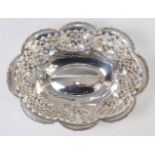 A George V silver table basket, of lobed and pierced form, with raised floral cast border,