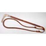 An early 20th century leather clad riding crop, having a silver mount and stag antler handle,