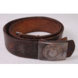 A German Wehrmacht belt buckle on a brown leather belt.