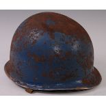 A WW II American M1 steel helmet with inner liner, webbing harness and chin strap.