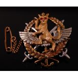 A 9 ct gold sweetheart brooch depicting a crowned rampant lion having garnet set eyes with crossed