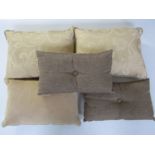 Five feather filled cushions, two in pale gold damask, one in pale gold chenille, and two in woven