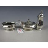 A George V silver cruet set, comprising baluster peperettes, mustard and salt (liner lacking),