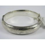 A silver hinged bangle, the face wriggle-work engraved with foliage, Birmingham, 1959, 21g