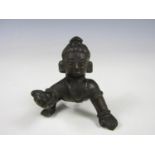 An Indian brass sculpture of a crawling child