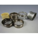 Three silver napkin rings together with a Victorian ivory napkin ring, a silver collared salt and