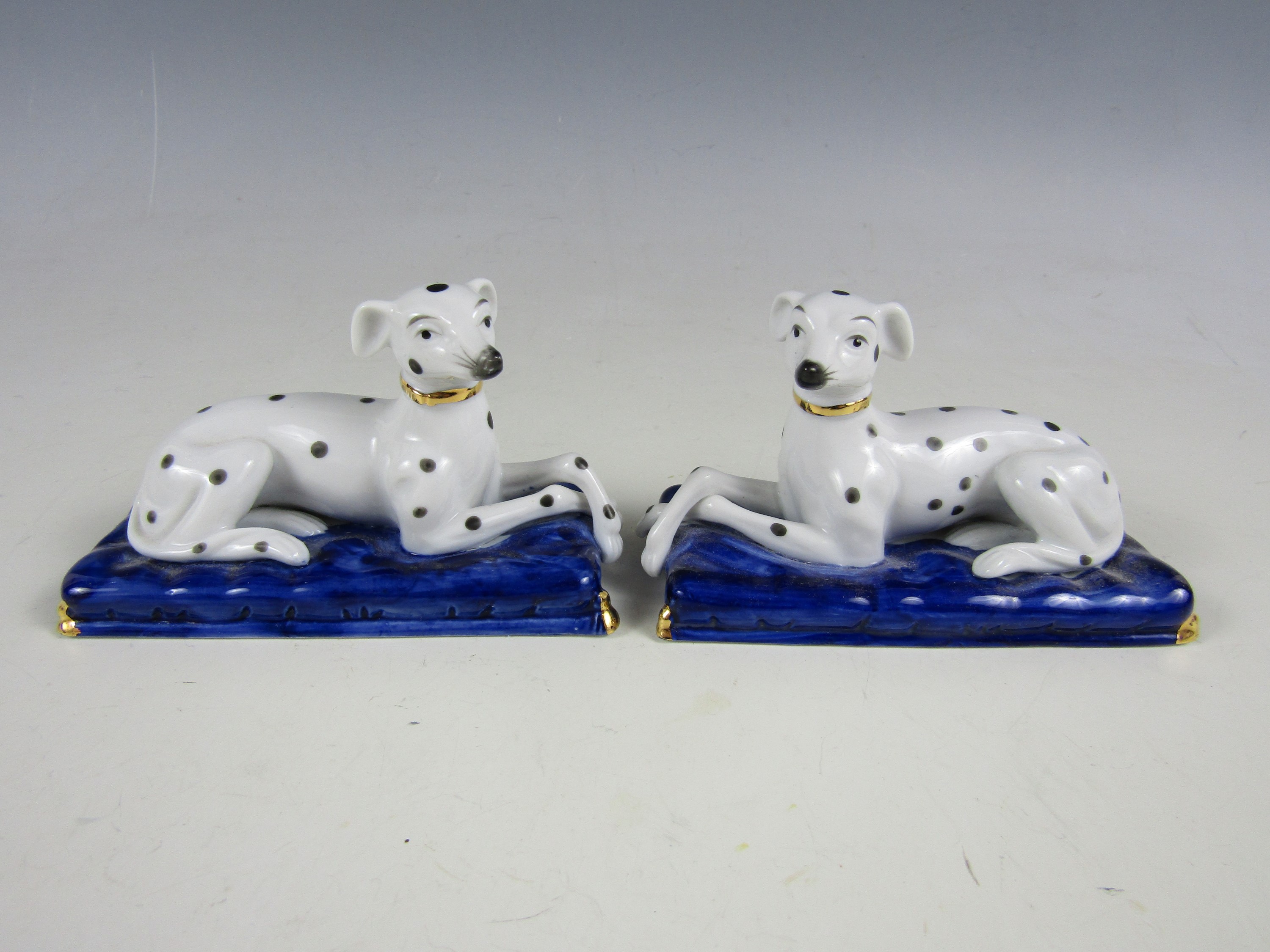 A pair of quality reproduction porcelain Dalmatians on cushions