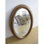 A large oval gilt framed bevelled edged wall mirror, second quarter 20th century