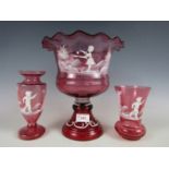 Three pieces of Mary Gregory style cranberry glass, including a campana form table centrepiece and