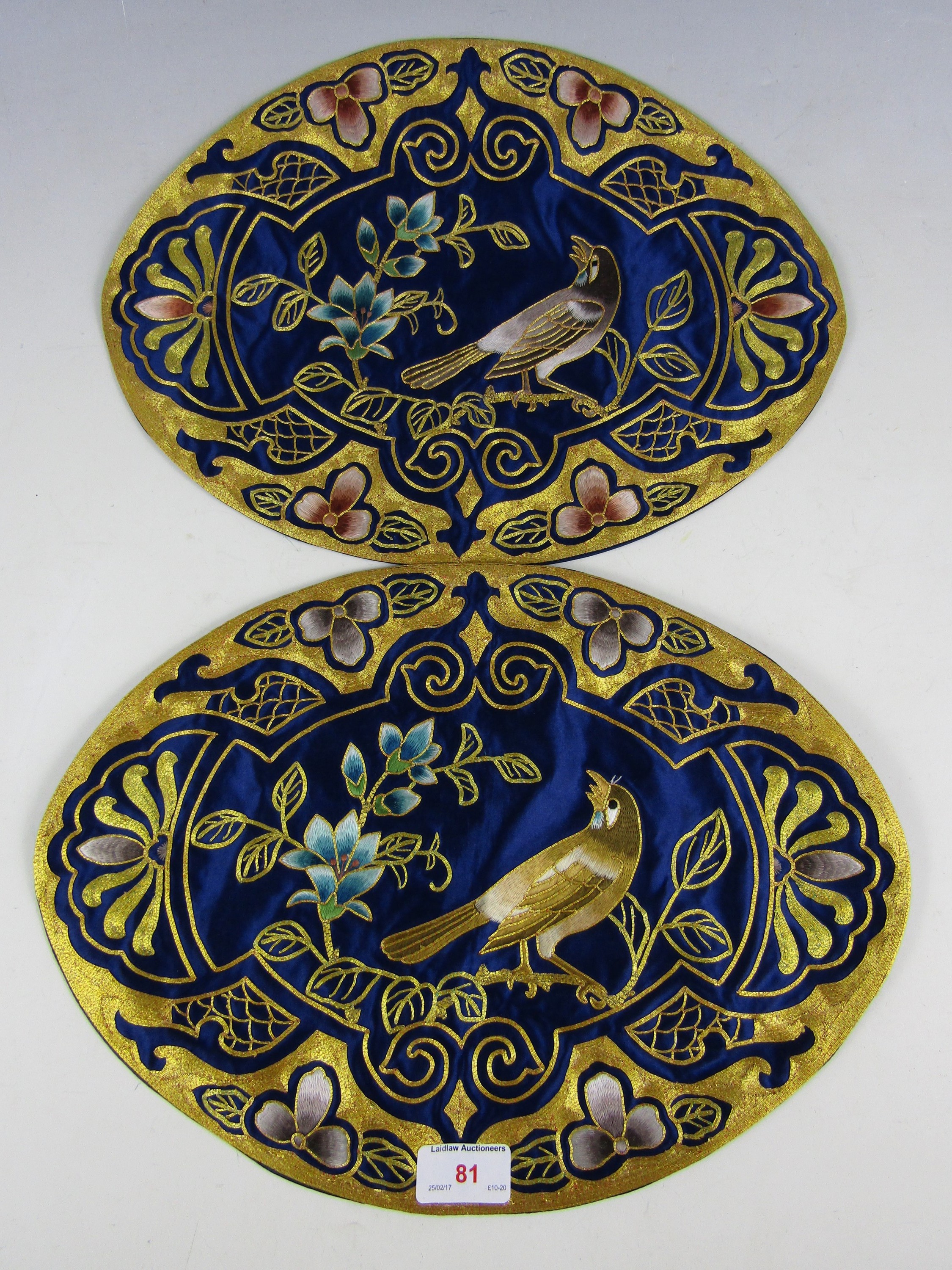 Two bullion and silk embroidered ornamental oval mats, each of cobalt blue silk, decorated with