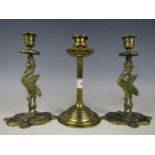 Two late 19th century cast brass candlesticks together with one other