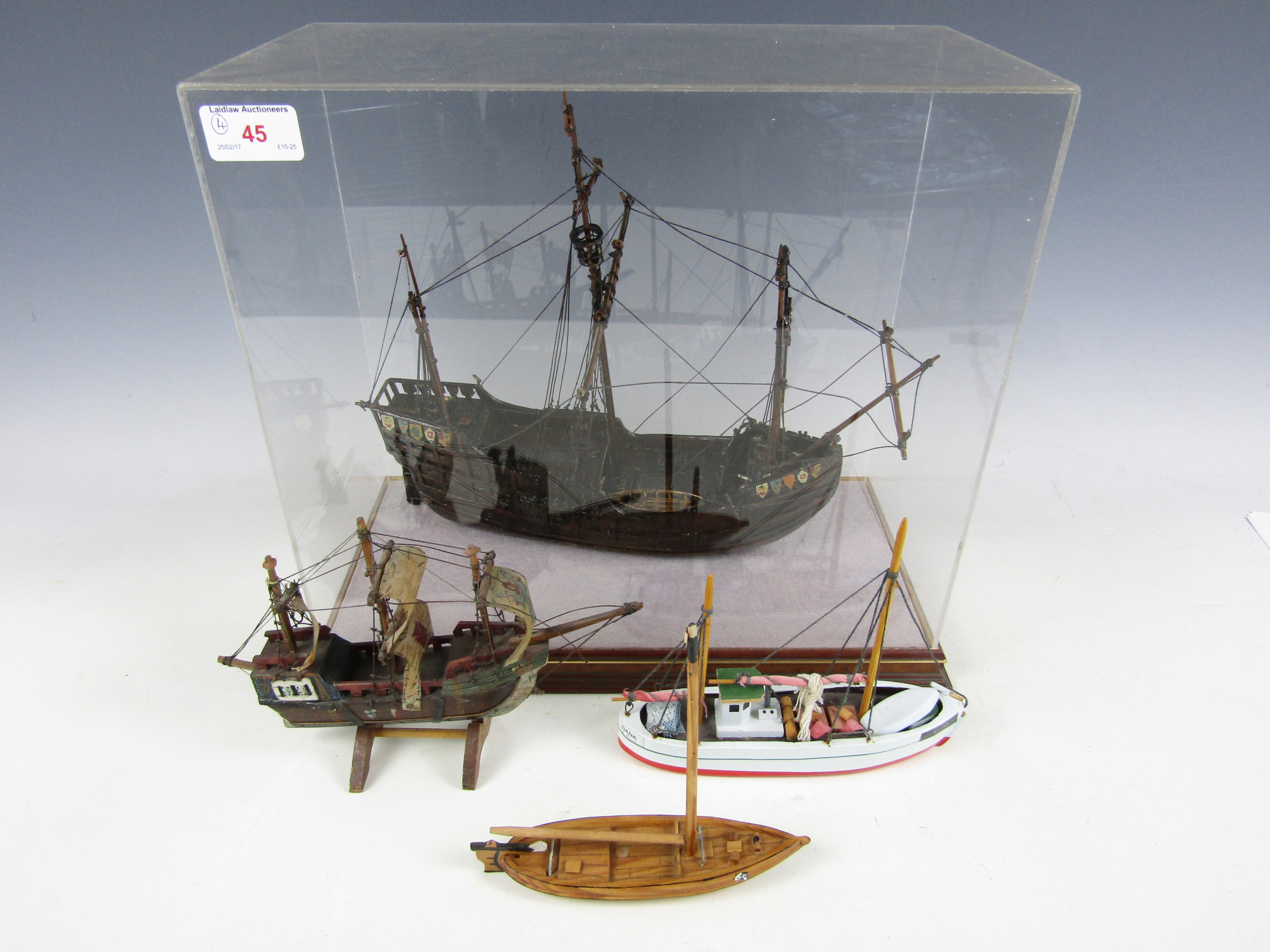 A cased model galleon together with three small wooden ships