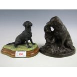 A black Labrador figurine together with a bronze effect statuette of girl with dog